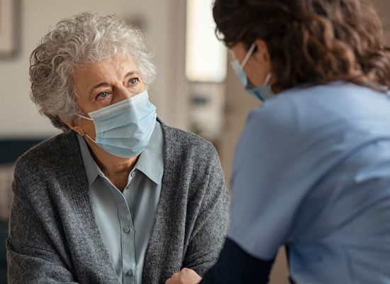 provider speaking with masked patient